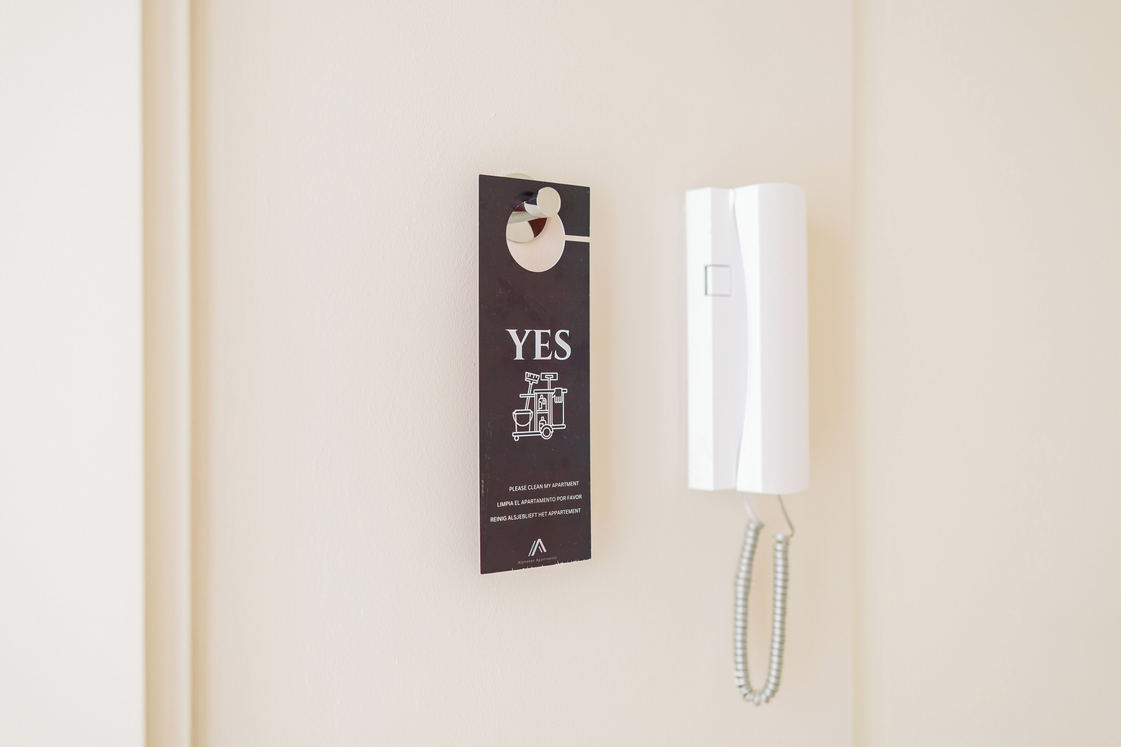 A wall-mounted telephone with a sign above it.