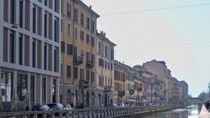 A canal with buildings on one side and a bridge in the foreground.