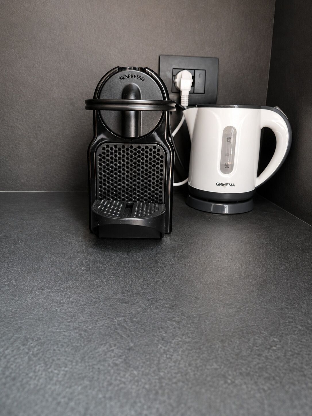 A Nespresso coffee machine and a white coffee maker on a countertop.