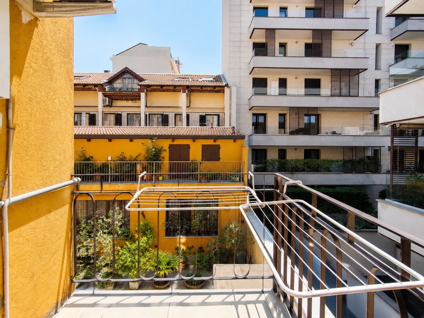 Un edificio residencial de varios pisos con balcones y fachada amarilla.
