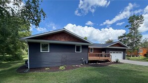 A two-story house with a front deck and a garage.