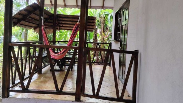 A covered outdoor area with a hammock, a table, and a chair. - luna caribena (Cahuita)