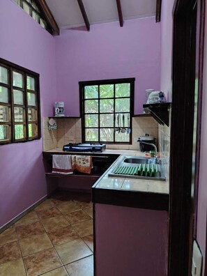 A compact kitchen with a window, a coffee maker, and a sink. - luna caribena (Cahuita)