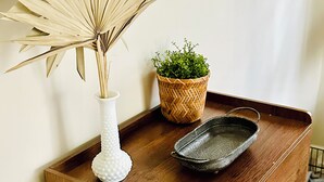 A wooden cabinet with a white vase and a woven basket containing a plant. - Hideaway Cabin. Relax and Enjoy (Manistee)