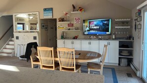 Eine geräumige Küche mit Essbereich, einem Fernseher, der 'DWI Crash' zeigt, und einem Deckenventilator.