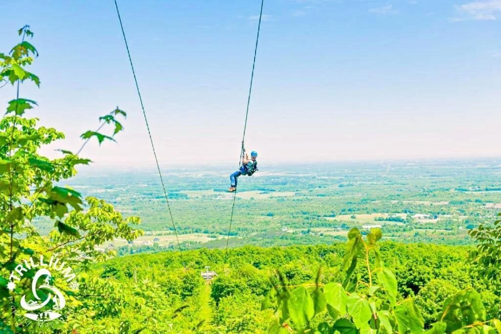 Una persona che vola su un paesaggio verde e rigoglioso, con una vista chiara del territorio sottostante.