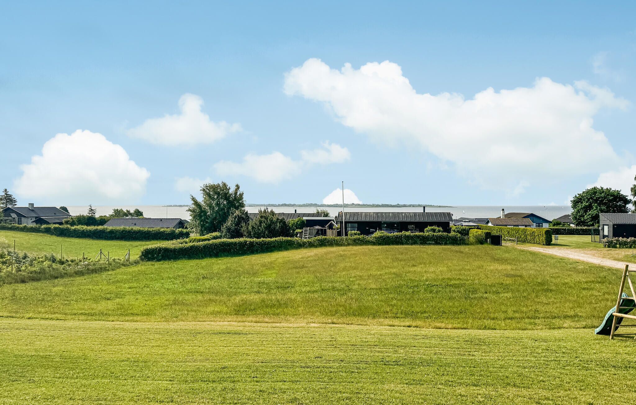 Ein grünes Feld mit einem Gebäude im Hintergrund.