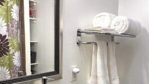 A bathroom with a white sink, a glass shelf with toiletries, a towel rack with towels, and a toilet. - Charming 1-bedroom apartment with WiFi, AC in marvelous Cincinnati (Cincinnati)