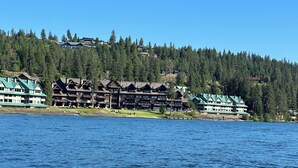A waterfront hotel with multiple buildings, large windows, and balconies overlooking a body of water. - FIREWORKS, LAKE ACCESS, BOAT MOORING OPTION - 3-bedroom unit Lake Coeur d'Alene (Harrison)