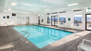 An indoor swimming pool with clear glass walls, a pool ladder, and a view of a mountainous landscape through large windows. - FIREWORKS, LAKE ACCESS, BOAT MOORING OPTION - 3-bedroom unit Lake Coeur d'Alene (Harrison)