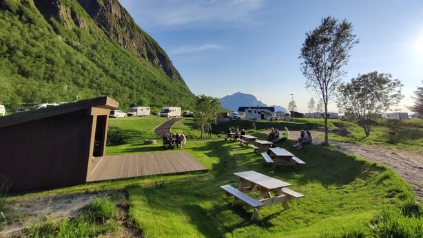 Un terrain de camping équipé de tables de pique-nique, d’emplacements pour camping-cars et offrant une vue imprenable sur les montagnes.