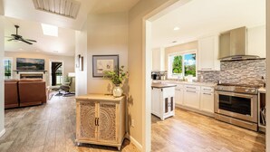 A spacious kitchen with modern appliances, a dining area with a large window, and a cozy living room with a fireplace.