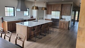Una cocina amplia con una isla grande, armarios de madera y electrodomésticos modernos.