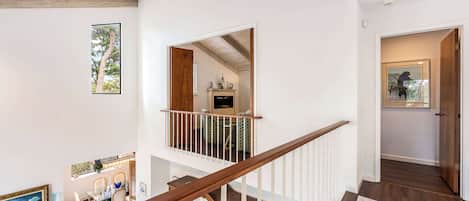A spacious interior with a wooden staircase, a dining area, and a view of the outdoors.