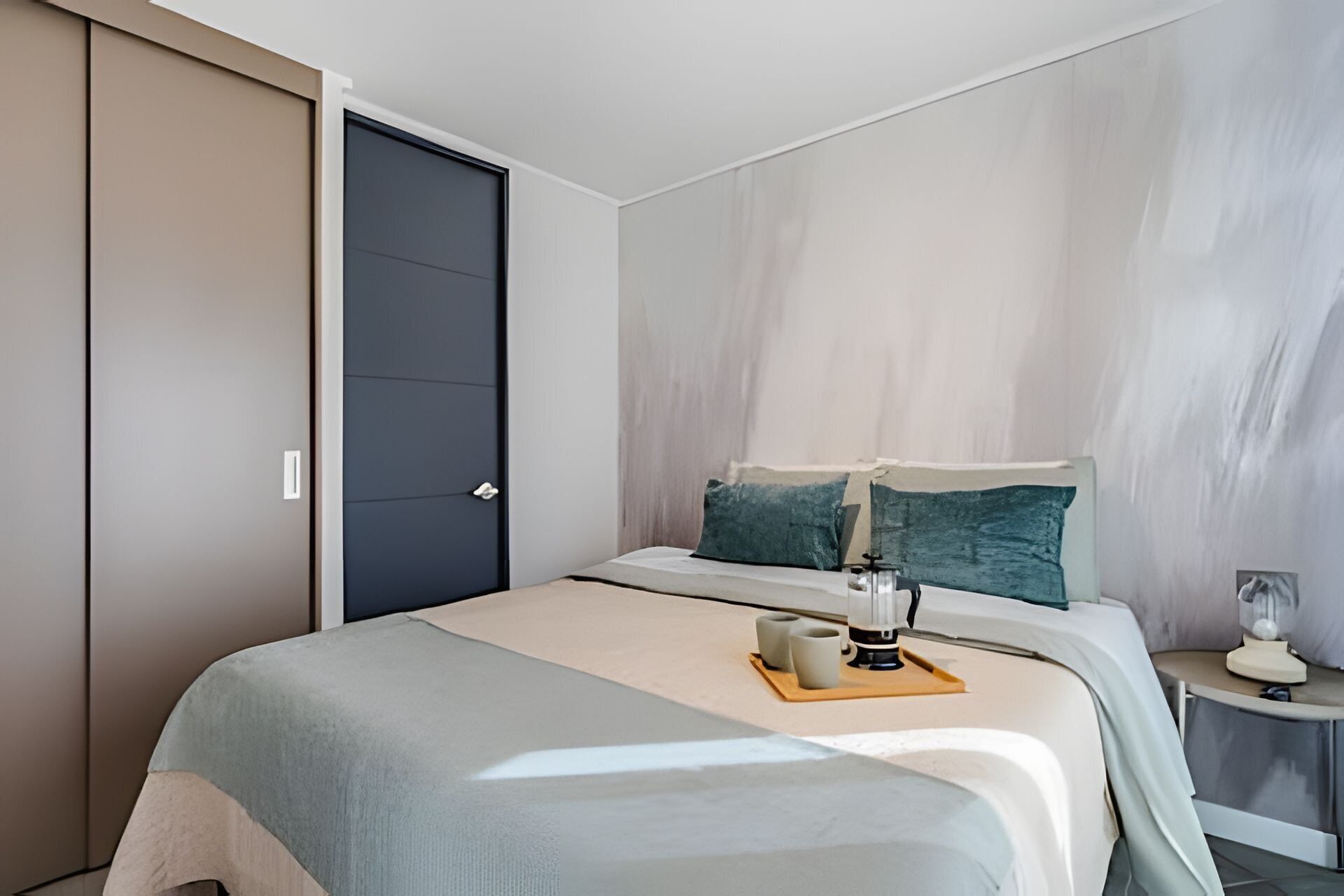 Un dormitorio moderno con cama, mesita de noche y una puerta.