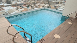 A rooftop pool with a city view, surrounded by buildings and a clear sky. - Santa Elvira Apartments (Santiago)