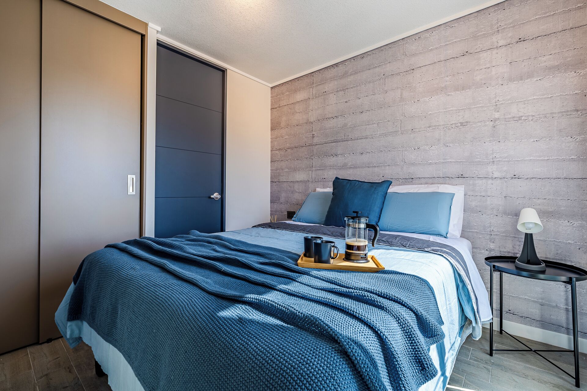 Ein Schlafzimmer mit einem Bett, einer Kaffeemaschine und einem Tablett mit zwei Tassen.