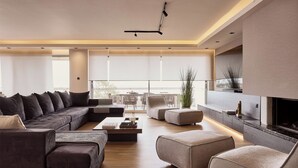 A modern living room with a sectional sofa, a coffee table, and a fireplace.