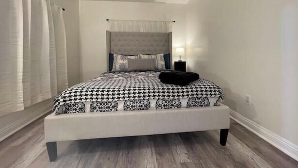 A bedroom with a bed, a ceiling fan, and a nightstand. - Superb Chambray 4 Beds, 2 Baths in Moreno Valley, CA. (Moreno Valley)