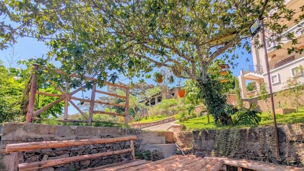 A rustic outdoor area with wooden structures and a stone wall. - Luxury Double Room in Karen Nairobi (Nairobi)
