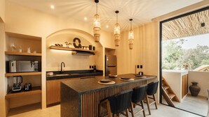 Een moderne keuken met een centraal eiland, houten planken en een groot raam.