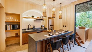 A modern kitchen with a central island, wooden cabinetry, and pendant lighting.