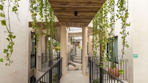 A corridor with hanging vines, a staircase, and a green directional sign. - Jungle Cove w private pool n concierge. 3p.  2 TVs (Tulum)