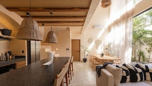 A modern kitchen with a large island, wooden beams, and pendant lighting. - Luxe Villa, 12p, 2 private pools, grill w/concierge (Tulum)