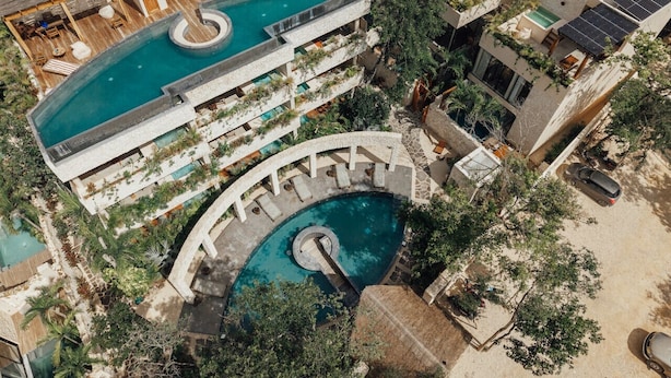 An aerial view of a resort with multiple swimming pools, outdoor seating areas, and solar panels on the rooftops. - Luxe Villa, 12p, 2 private pools, grill w/concierge (Tulum)