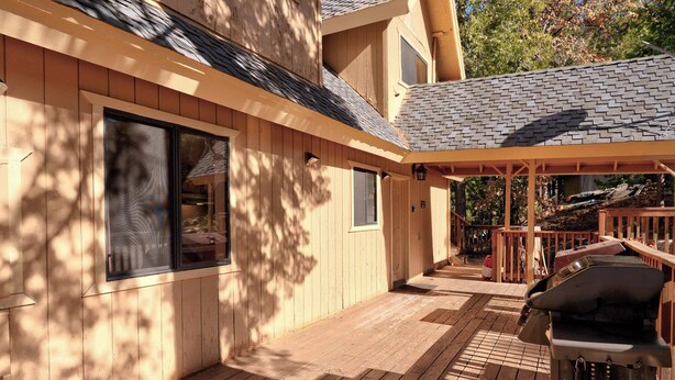 A wooden deck with a barbecue grill and a covered area with a railing. - Yosemite Aviary - Bird's Eye View! Awesome Upper Unit! (Yosemite National Park)