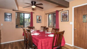 A dining room with a red tablecloth, wooden chairs, and a ceiling fan. - Yosemite Aviary - Bird's Eye View! Awesome Upper Unit! (Yosemite National Park)