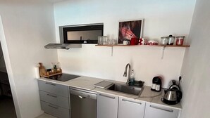 Una cuina moderna amb rentaplats, rentamans i cafetera.