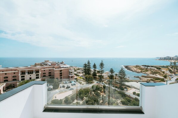 Un edificio alto con vista a una zona costera, incluyendo una playa y el océano.