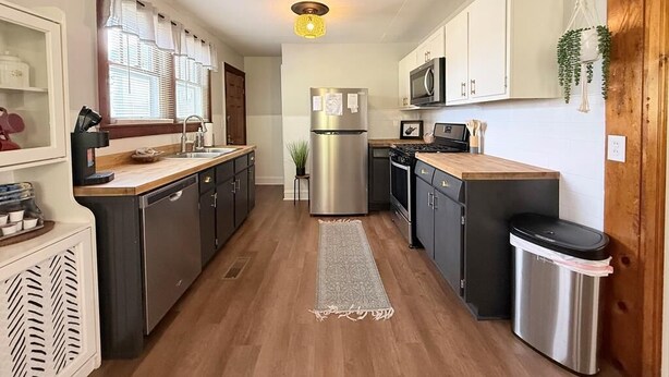 A modern kitchen with wooden cabinets, stainless steel appliances, and a central island.