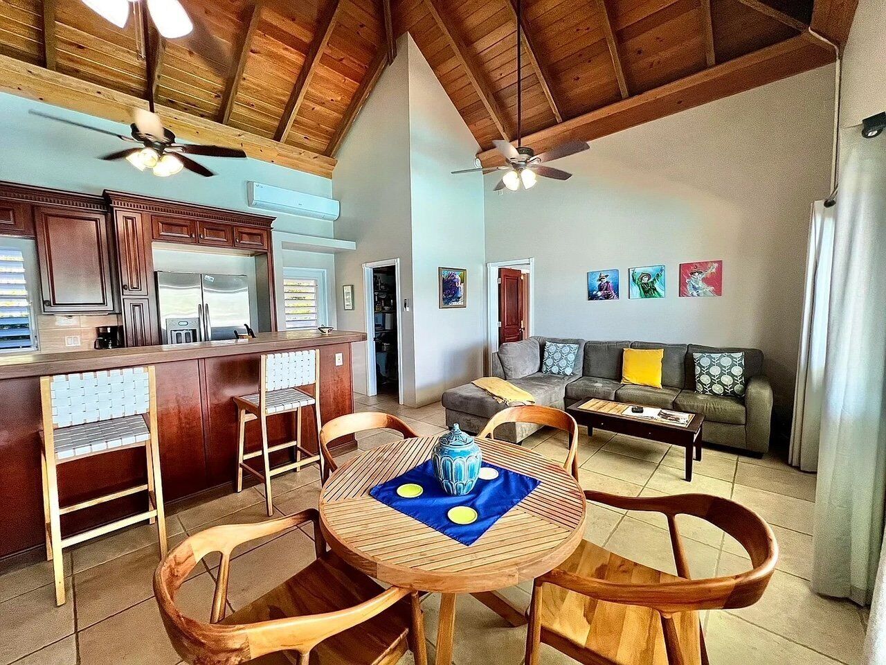 Een ruime woonkamer met een eettafel, stoelen, een bank en een keuken met een bar.