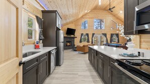 Una cocina moderna con paredes de madera, una isla central y una chimenea.
