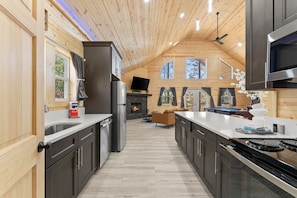 Una cocina moderna con paredes de madera, una isla central y una chimenea.