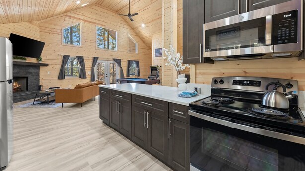 Una cocina moderna con una isla grande, electrodomésticos de acero inoxidable y una chimenea.