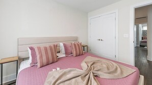 A bedroom with a bed, pillows, a bedside table, and a door. - 19 Bed Home Near Downtown with Game room (Nashville)