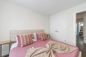 A bedroom with a bed, pillows, a bedside table, and a door. - 19 Bed Home Near Downtown with Game room (Nashville)