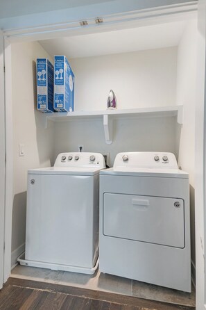 A laundry room with two front-loading washing machines and two stacked drying machines. - 19 Bed Home Near Downtown with Game room (Nashville)