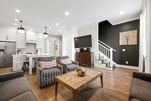 Un espacio de estar moderno con cocina, comedor y zona de descanso.