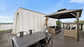 A covered outdoor patio with a table and chairs, a wicker sofa, and a pergola. - 19 Bed Downtown Rooftop Gameroom Walk To Broadway (Nashville)