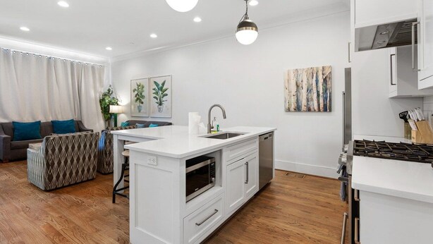 A modern kitchen with white cabinetry, a built-in oven, and a gas stove. - 19 Bed Downtown Rooftop Gameroom Walk To Broadway (Nashville)