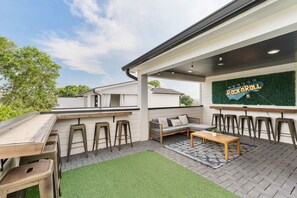 Un espace extérieur aménagé en terrasse, avec un bar, des sièges et un panneau décoratif sur le thème du rock and roll.