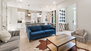 A modern living room with a blue sofa, a wooden coffee table, and a cowhide rug.