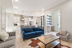 Un salon moderne avec un canapé bleu, une table basse en bois et un tapis en peau de vache.