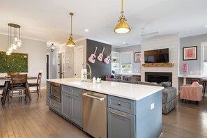 A modern kitchen with a central island, stainless steel appliances, and pendant lighting.