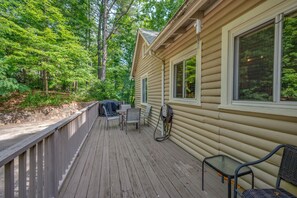 Une terrasse en bois avec des meubles d’extérieur, une table abritée et une prise électrique.