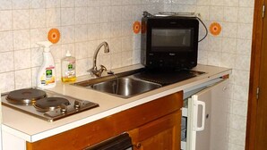 A kitchen with a built-in microwave, a sink, and a stove.
